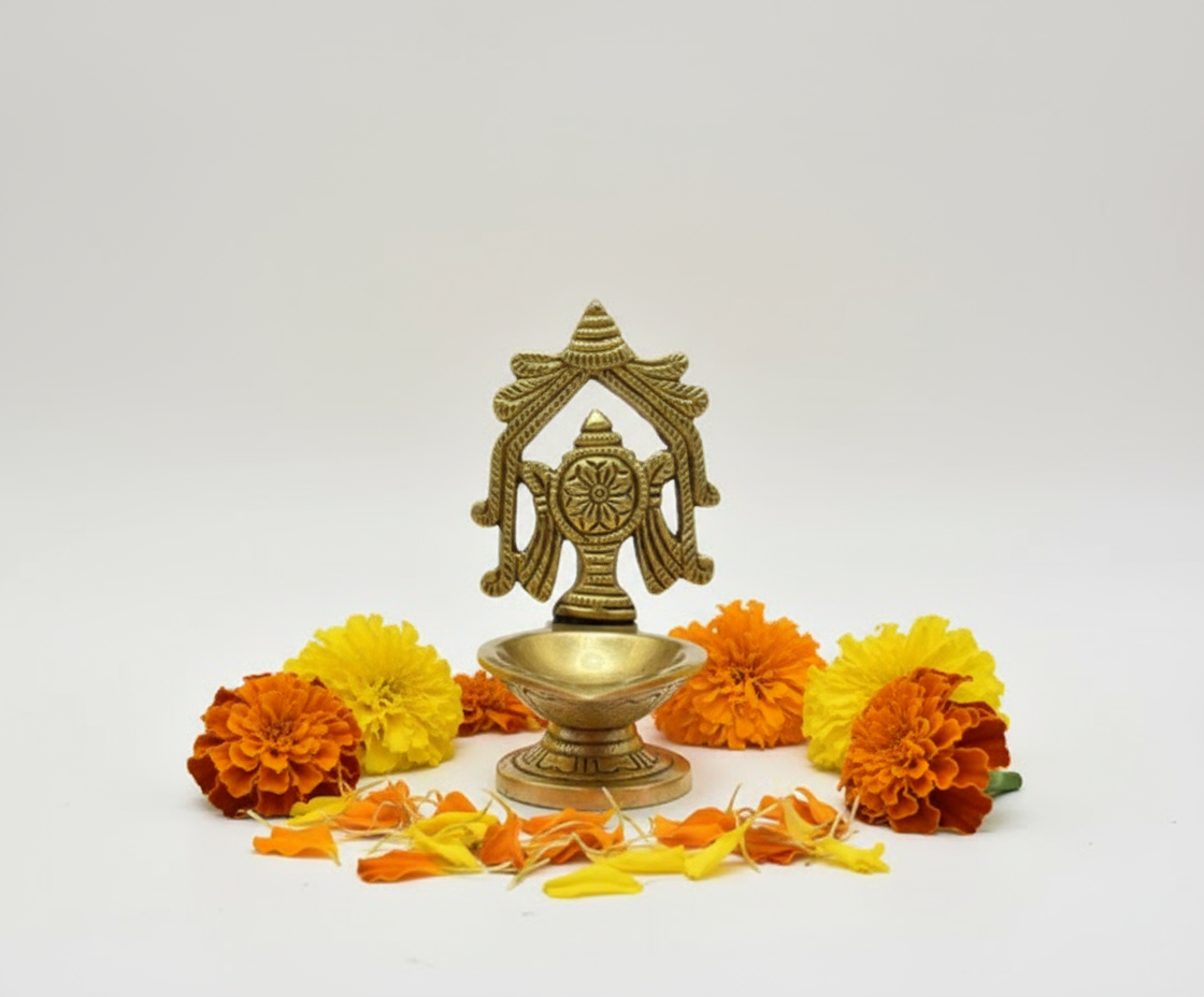 Brass diya on pristine white background with marigold flowers